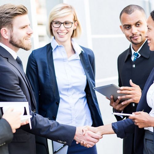 Eine Gruppe junger Geschäftspartner begrüßt sich.